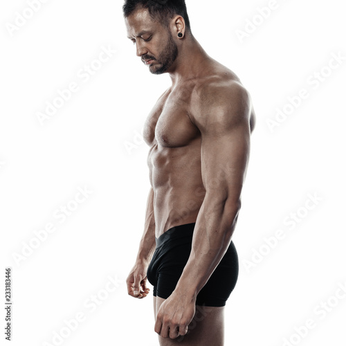 Brutal strong bodybuilder athletic man posing on white background.