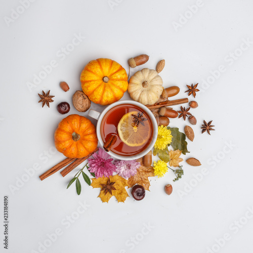 Autumn composition. A cup of fragrant tea surrounded by dry leaves, nuts, flovers and pumpkins