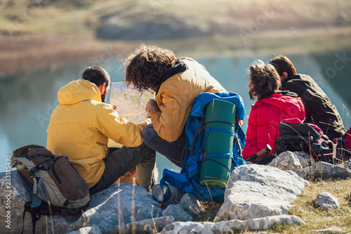 Group of people taking a break, relaxing during a hike, looking at the map. © Mediteraneo