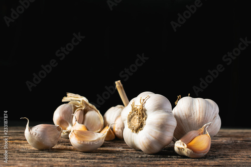 Closeup garlic on wooden texture on for cooking on dark background