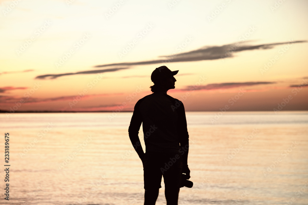 Silhouette of man with the camera and sunset. Photographer and sunset