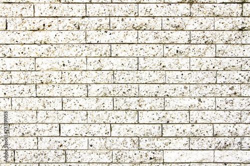 Simple grungy white brick stone wall as seamless pattern texture background.