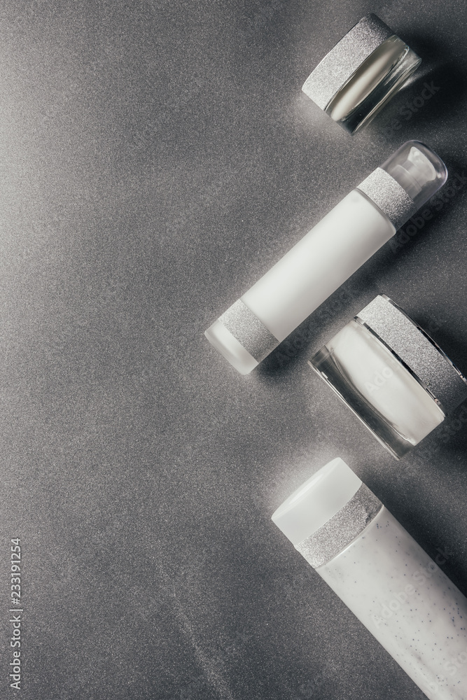 Naklejka premium view from above of beauty cream and lotion on silver