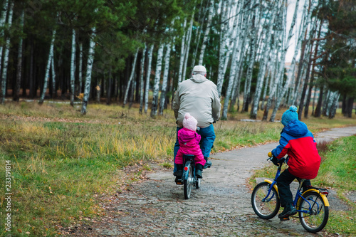 Fototapeta Naklejka Na Ścianę i Meble -  active senior with grandkids riding bikes in nature