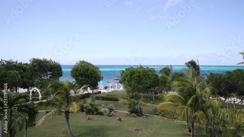 Beautiful Coconut palms and path to the Blue Atlantic Ocean beach in Holguin district of Cuba - October 31 2108. photo