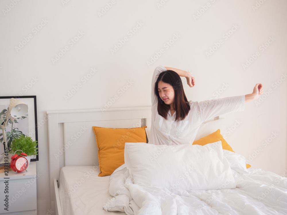 asian woman stretching in bed after wake up