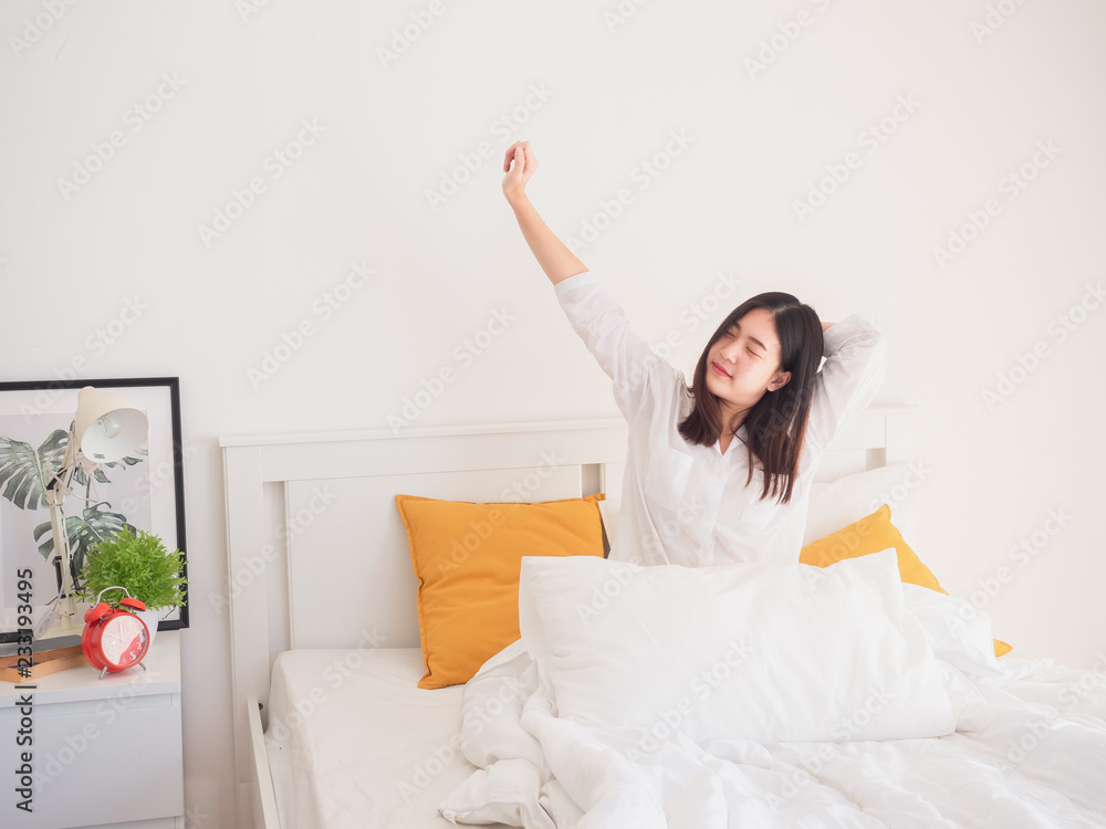 asian woman stretching in bed after wake up asian woman stretching in bed after wake up