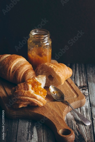 Close up of croissants and marmalade on cutting board photo