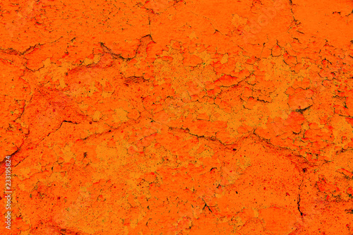 Grungy and old weathered orange wall surface texture background marked by long exposure to the elements outdoors and with cracked painting coating peeling off.
