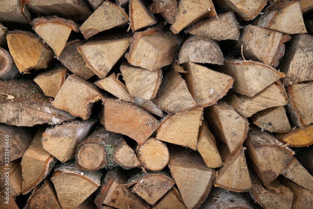 Neatly stacked wooden firewood. Stoke the fireplace. Background. Neatly stacked wooden firewood. Stoke the fireplace. Background.