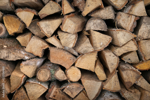 Neatly stacked wooden firewood. Stoke the fireplace. Background.