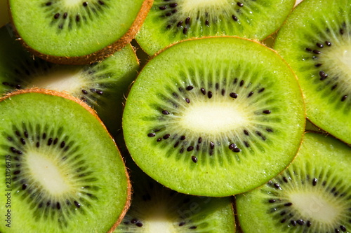 Sliced green fresh kiwi fruit pieces lying on table, flat lay view, healthy diet