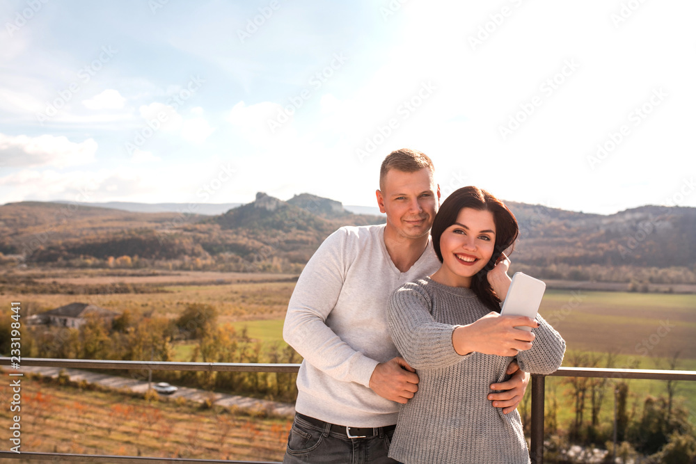 Happy couple making selfie against the mountains. Happy couple making selfie against the mountains.