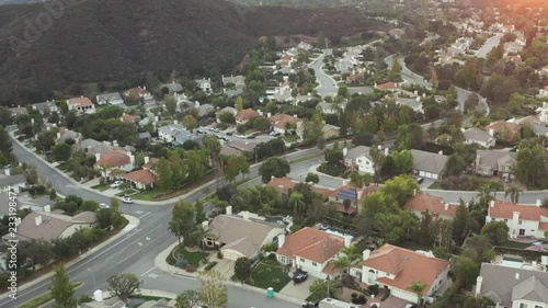 The Sunset over a residential area in between green mountiains in Southern California