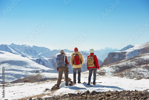 Three tourists stands on mountain pass