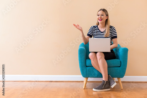 Young woman with a laptop computer in a chair