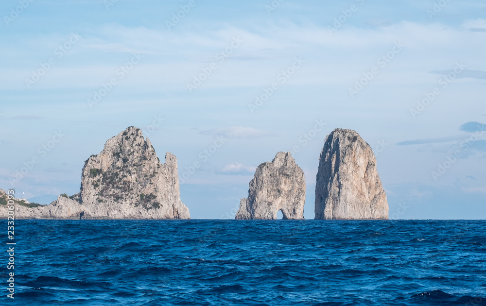 Famous sea stacks (faraglioni) off the coast of Capri in the Bay of Naples, the Mediterranean Sea, Southern Italy. 