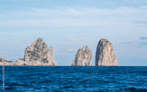 Famous sea stacks (faraglioni) off the coast of Capri in the Bay of Naples, the Mediterranean Sea, Southern Italy. 