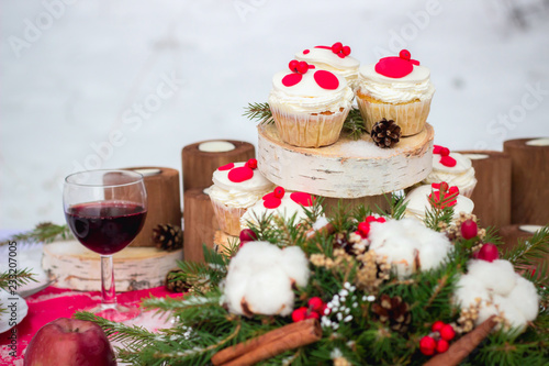 Festive table setting for Christmas for two with cupcakes, red wine