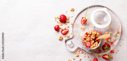 Granola Cereal bar with Strawberries on the Gray Background in a glass jar. Muesli Breakfast. Healthy Food sweet dessert snack. Diet Nutrition Concept. Top View. Vegetarian food.Flat Lay.Copy space