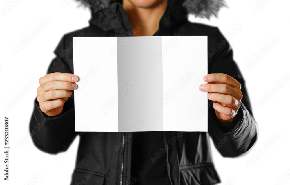 A man in a warm winter jacket holding a white leaflet. Blank paper. Close up. Isolated on white background A man in a warm winter jacket holding a white leaflet. Blank paper. Close up. Isolated on white background
