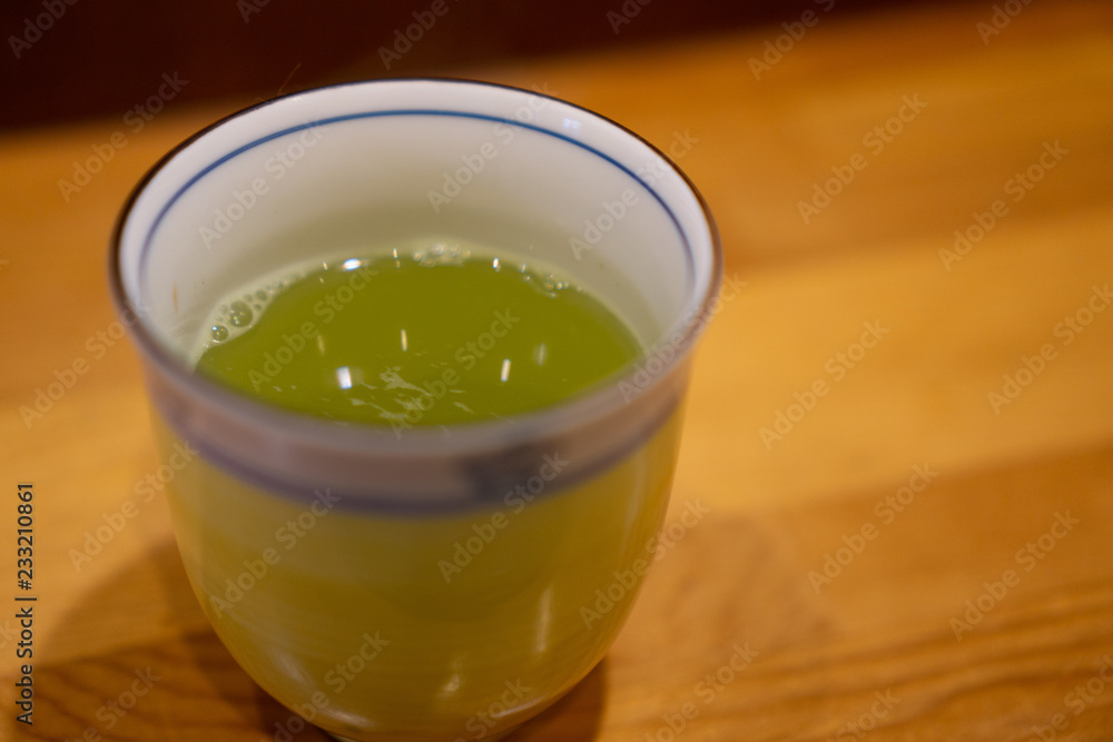 Hot green tea in ceramic cup in Japanese restaurant Hot green tea in ceramic cup in Japanese restaurant