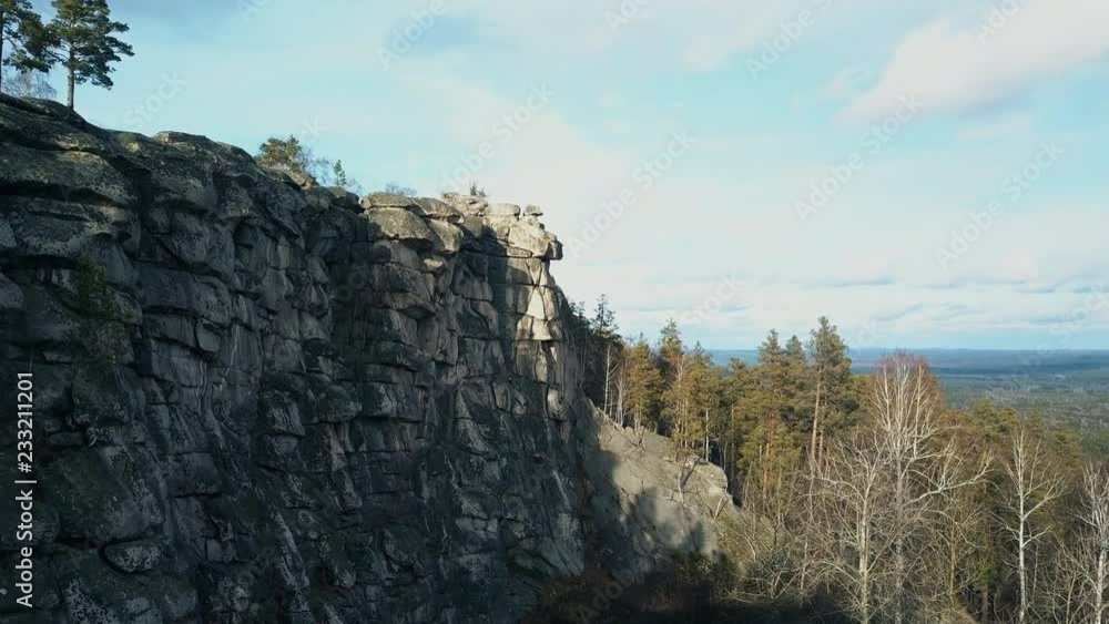 Aerial; drone flight along the huge and high stone wall; great place for climbers pastimes and other leisure activity; popular tourist route in late autumn with dramatic landscape, South Ural, Russia Aerial; drone flight along the huge and high stone wall; great place for climbers pastimes and other leisure activity; popular tourist route in late autumn with dramatic landscape, South Ural, Russia