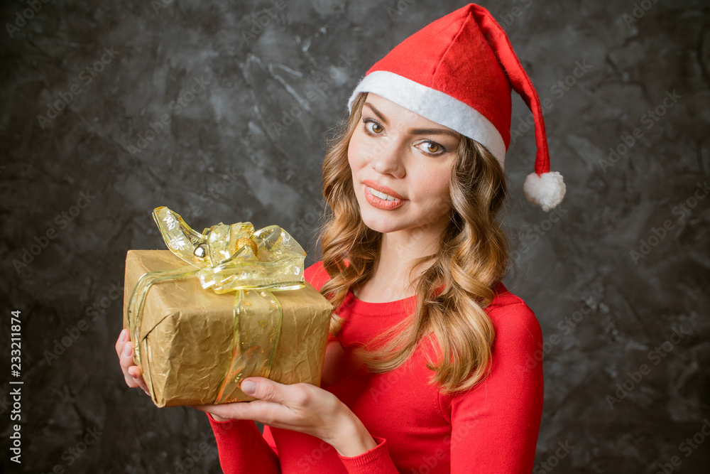 beautiful girl with a Christmas gift dressed in a Christmas hat beautiful girl with a Christmas gift dressed in a Christmas hat
