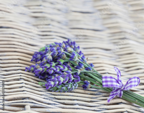 Lavender bouquet with a  chequered bow ribbon on a wicker background with copy space