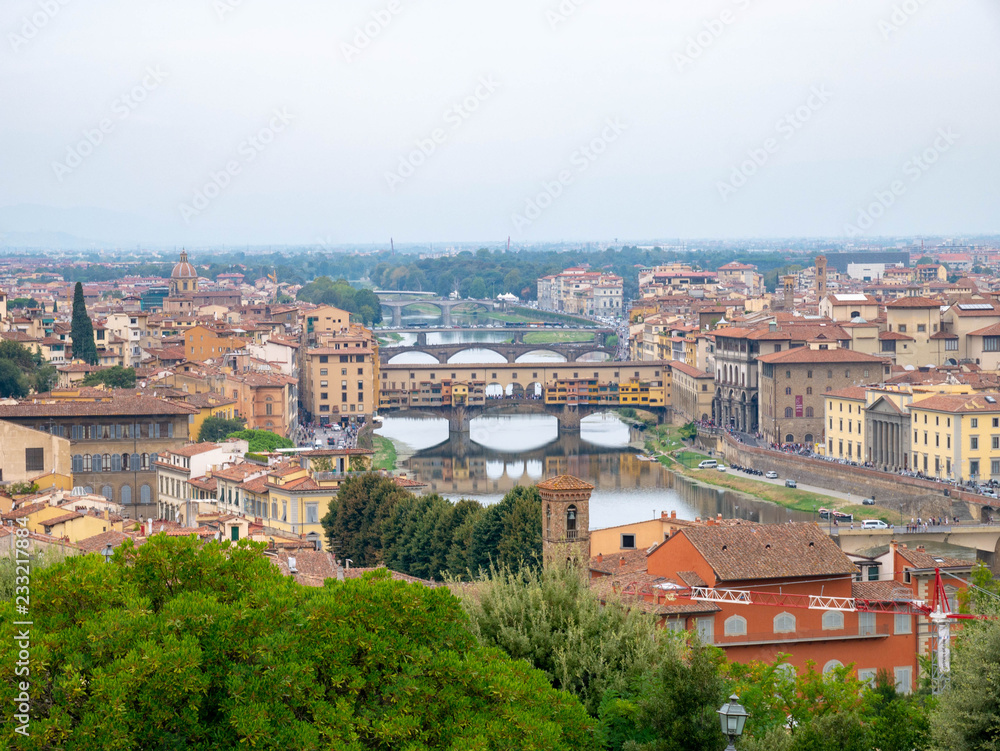 Panorama of Florence, Italy, showing the skyline with churches, cathedrals and palaces, the river San Lorenzo and the bridge on a cloudy summer day, seen from high above