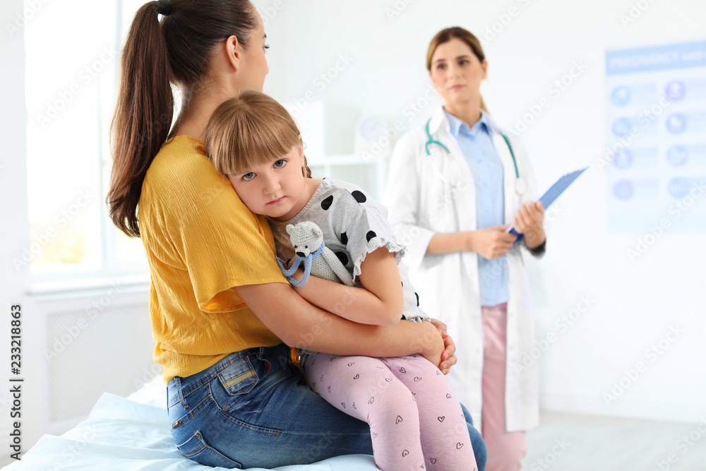 Little girl with parent visiting children's doctor in hospital Little girl with parent visiting children's doctor in hospital