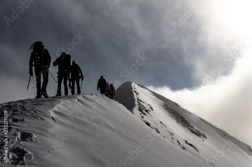 Fototapeta Mountaineers on a snowy mountain ridge