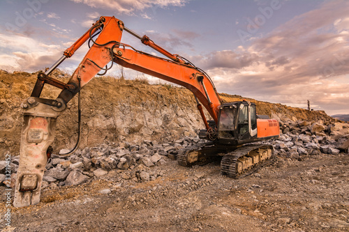 Earth moving by a bulldozer in the construction of a road in Spain. Hydraulic hammer for backhoe