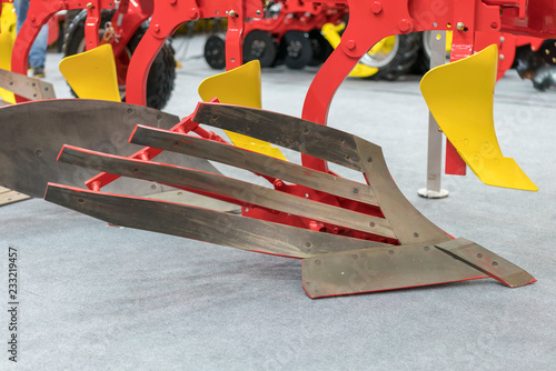 Corn harvester head with several silver blades. Agricultural machinery for soil cultivation.
