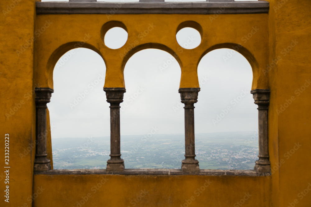 Terrace with yellow arches overlooking view from the Pena Palace in Sintra Portugal