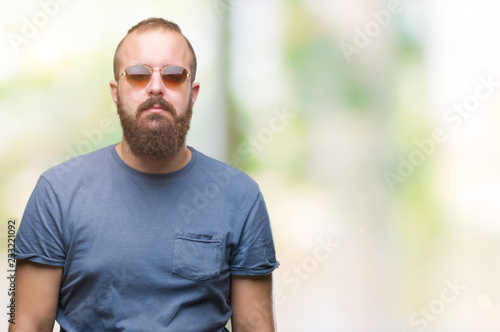 Young caucasian hipster man wearing sunglasses over isolated background cheerful with a smile of face pointing with hand and finger up to the side with happy and natural expression on face