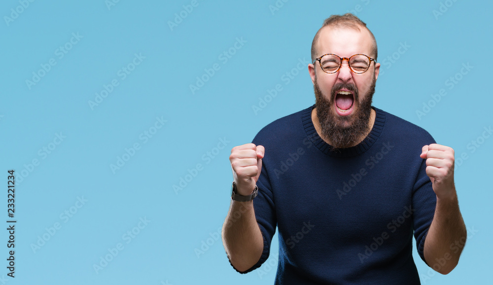 Naklejka premium Young caucasian hipster man wearing sunglasses over isolated background cheerful with a smile of face pointing with hand and finger up to the side with happy and natural expression on face