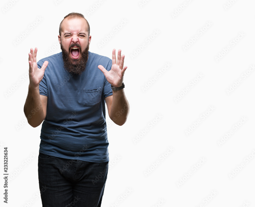 Young caucasian hipster man over isolated background crazy and mad shouting and yelling with aggressive expression and arms raised. Frustration concept. Young caucasian hipster man over isolated background crazy and mad shouting and yelling with aggressive expression and arms raised. Frustration concept.