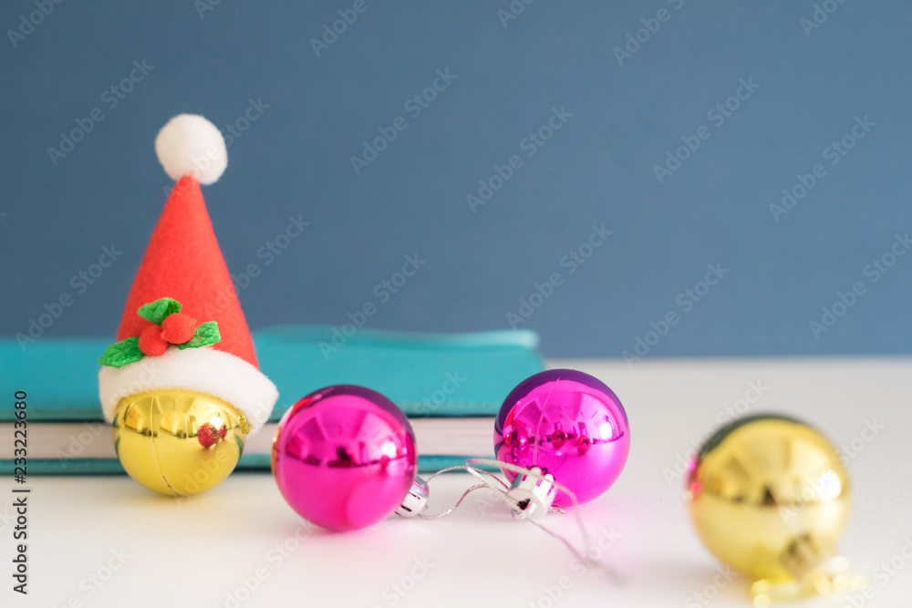 Christmas concept with copy space.Ornament balls, Santa Claus hat and note book with blue background.