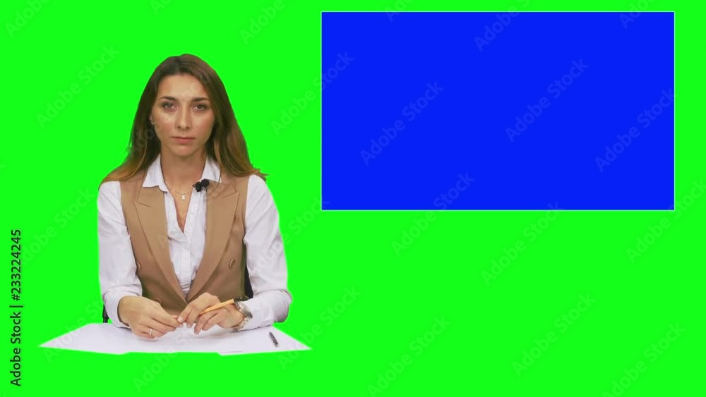 Female news presenter, tv presenter in green studio with blue screen display for mockup usage. Footage with alfha channel Female news presenter, tv presenter in green studio with blue screen display for mockup usage. Footage with alfha channel
