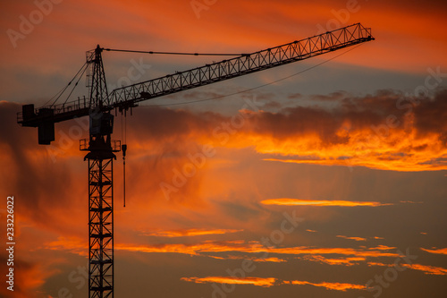 Silhouette of construction crane in front of sunset