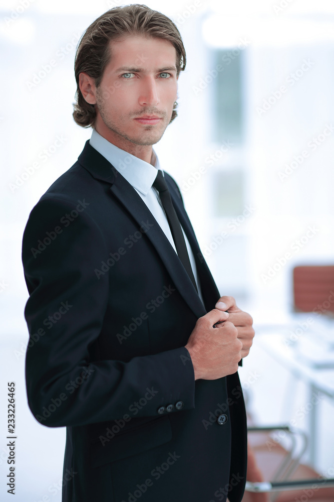 portrait of confident businessman on background of office portrait of confident businessman on background of office