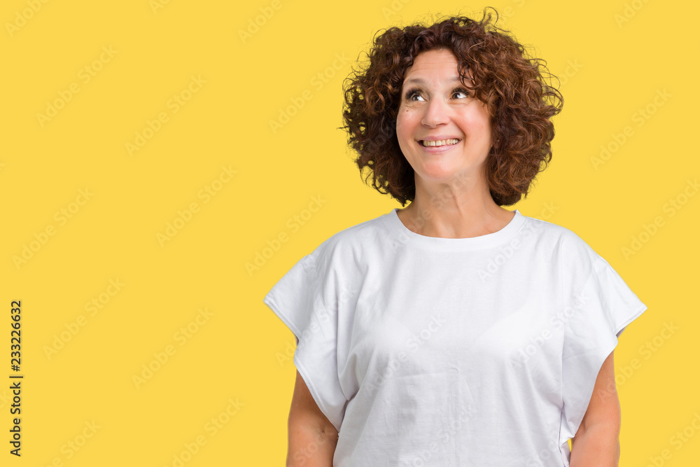 Beautiful middle ager senior woman wearing white t-shirt over isolated background smiling looking side and staring away thinking. Beautiful middle ager senior woman wearing white t-shirt over isolated background smiling looking side and staring away thinking.