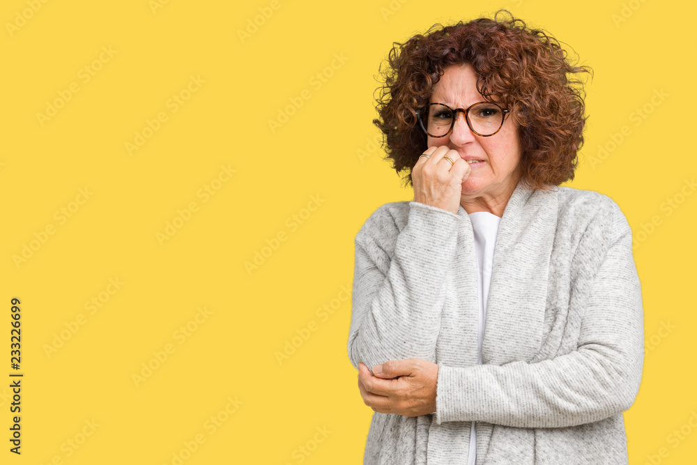 Beautiful middle ager senior woman wearing jacket and glasses over isolated background looking stressed and nervous with hands on mouth biting nails. Anxiety problem. Beautiful middle ager senior woman wearing jacket and glasses over isolated background looking stressed and nervous with hands on mouth biting nails. Anxiety problem.