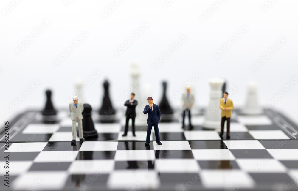 Miniature people, Group Businessmen standing on the chess game, thinking solution for the business game, use as a business competition concept. Miniature people, Group Businessmen standing on the chess game, thinking solution for the business game, use as a business competition concept.