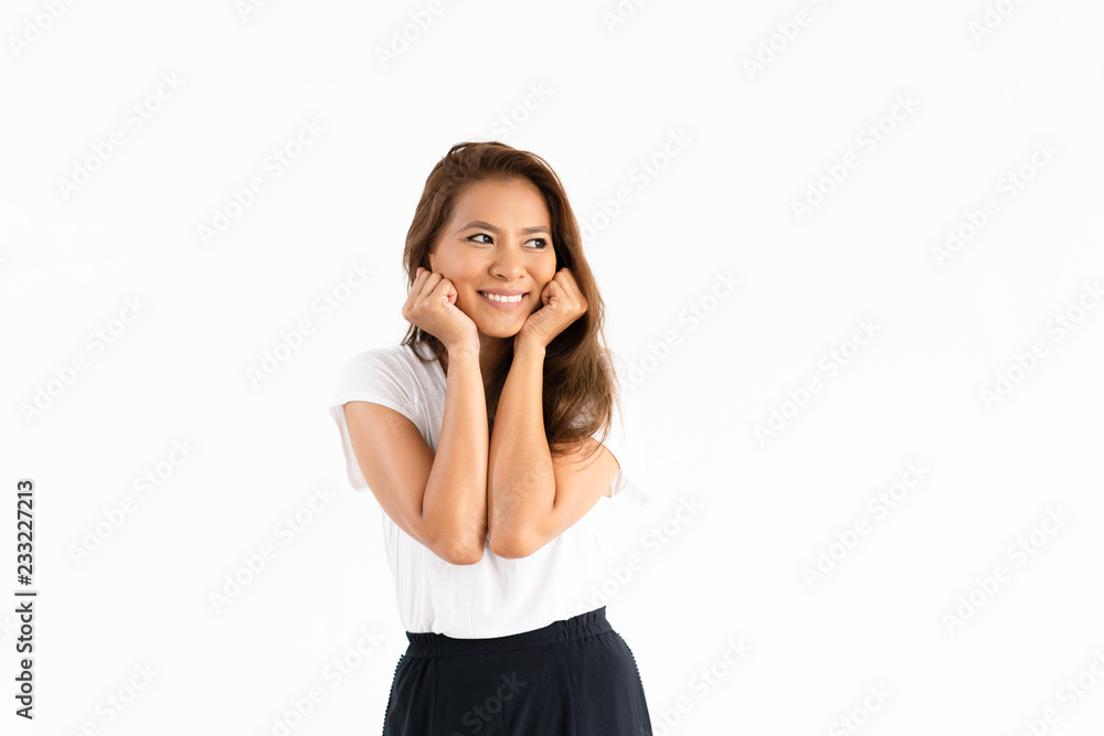 Happy girl touching cheeks and studying copy space away. Beautiful smiling young woman leaning head on hands and looking into distance. Thinking or skin care concept Happy girl touching cheeks and studying copy space away. Beautiful smiling young woman leaning head on hands and looking into distance. Thinking or skin care concept