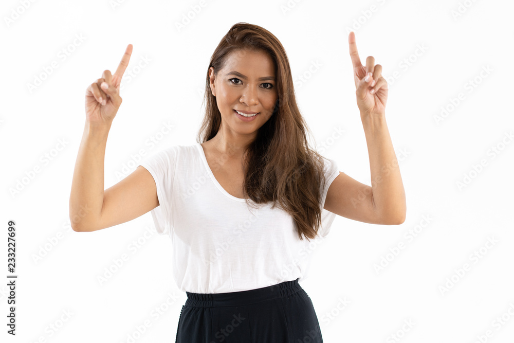 Positive Latin girl presenting new product or service. Cheerful young woman pointing fingers up Presentation concept Positive Latin girl presenting new product or service. Cheerful young woman pointing fingers up Presentation concept