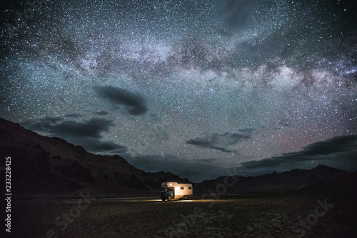 camping truck in remote tajik mountain landscape under starry night sky photo
