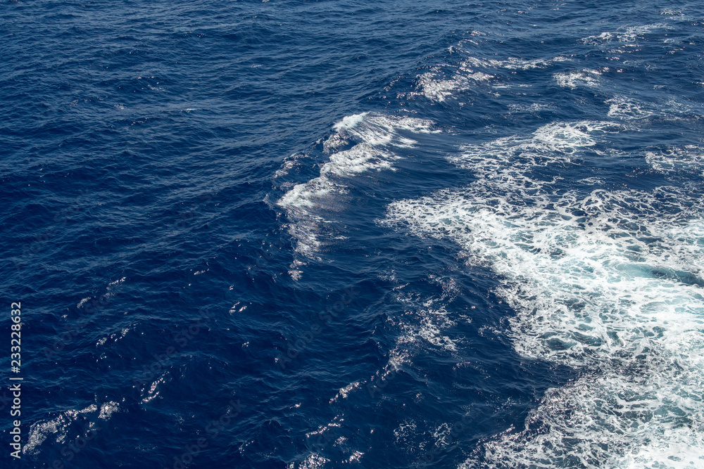 Blue ocean waves with white scallops of sea foam.
