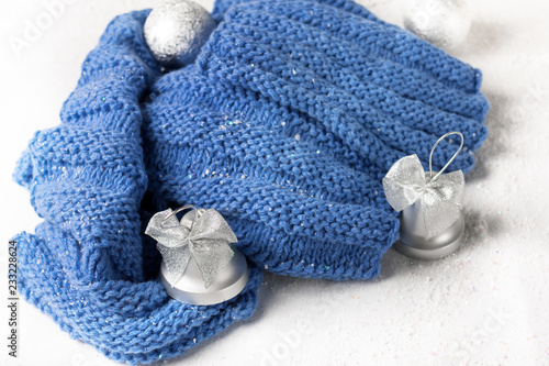 wool knitted scarf handmade deep blue colow with silver christmas toys on the snow table white